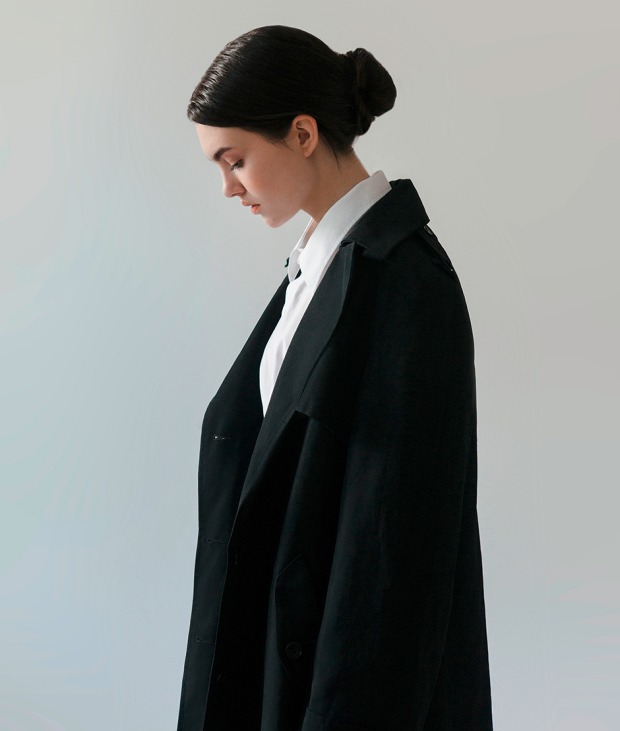 Junge Frau in weißer Bluse und schwarzem Mantel | Credit: iStock.com/ta-nya