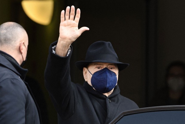 Silvio Berlusconi mit FFP2-Maske winkt den Journalisten zu.