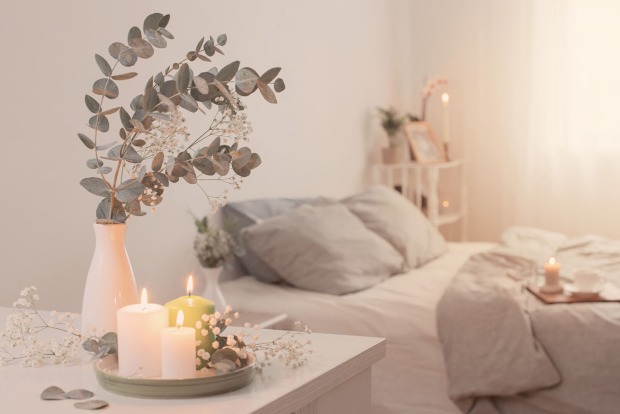 Kerzen stehen neben einem Bett | Credit: iStock.com/Maya23K