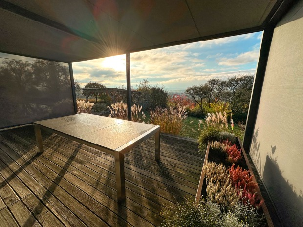 Überdachte Terrasse mit Blick auf idyllische Landschaft im Grünen | Credit: Schwaighofer