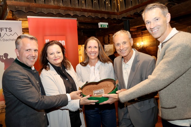 Gruppenbild, gemeinsam eine Torte in Herzform zeigend