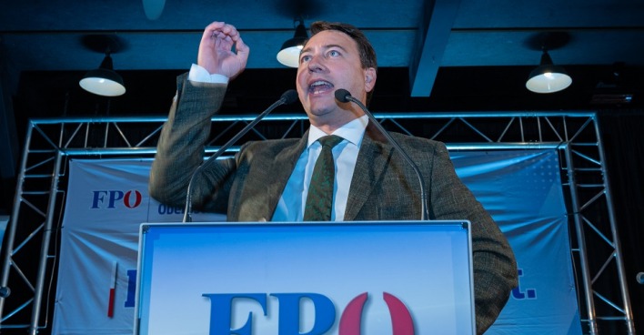 Landeshauptmannstellvertreter Michael Haimbuchner hält auf einer Bühne mit FPÖ Podium eine Rede.