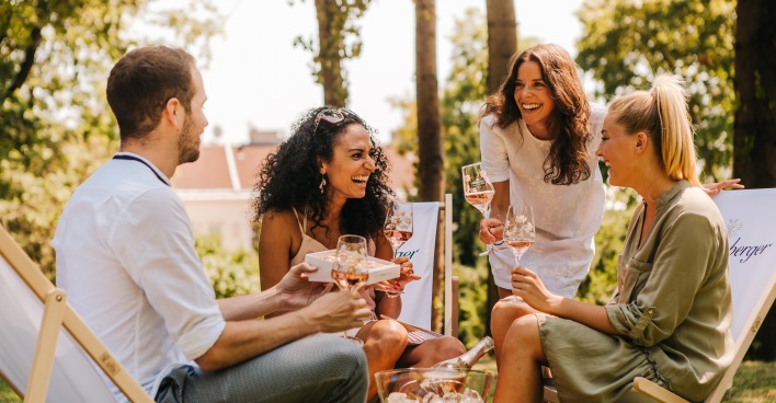 Freundesrunde trinkt im Garten Sekt