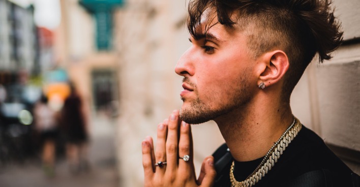 Profilfoto des jungen Rappers Gavis Dean, der an einer Gebäudefassade lehnt