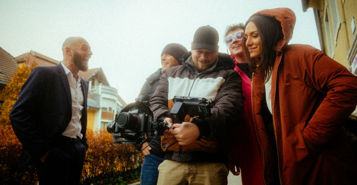 Die Filmcrew des Tourismusclips begutachtet während einer Drehpause einen Kamerabildschirm