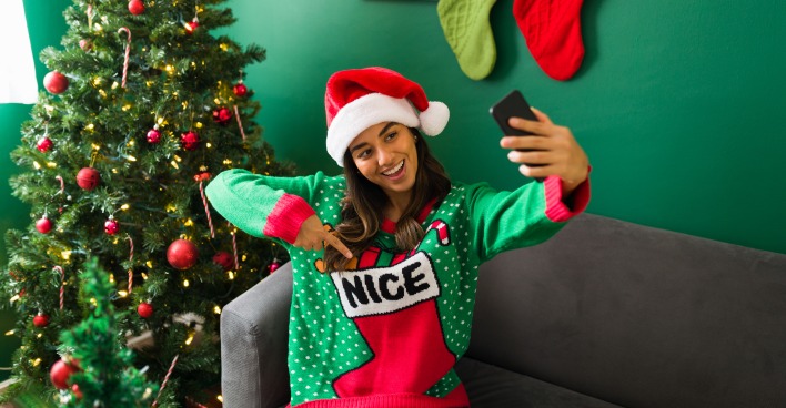 Mädchen fotografiert sich in einem Weihnachtspulli