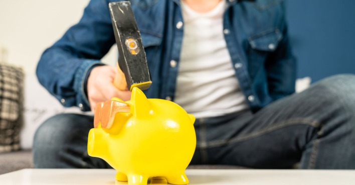 Mann zerschlägt gelbes Sparschwein | Credit: iStock.com/Jens Rother
