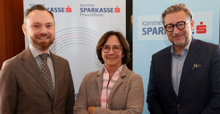 Michael Koren, Gabriele Semmelrock-Werzer und Manfred Bartalsky stehen vor zwei Rollups der Kärntner Sparkasse