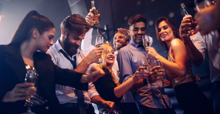 Partypeople mit Bier und Champagner beim Tanzen