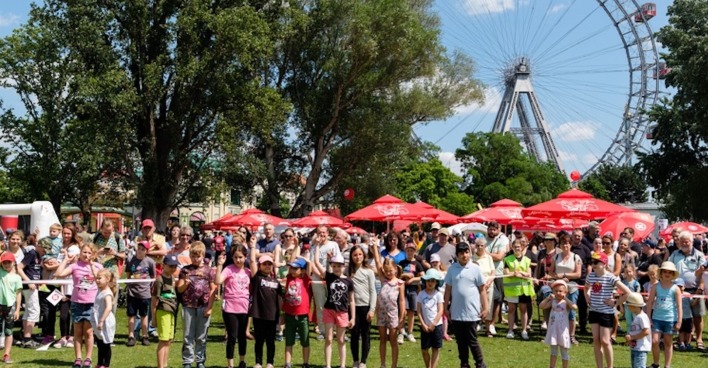 Kinder und Erwachsene bei einem Fest vor dem Wiener Riesenrad | Credit: Benjamin/ASB