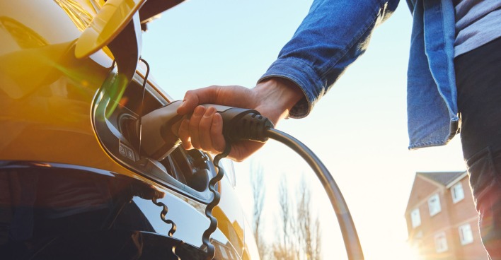 Mann lädt sein E-Auto | Credit: iStock.com/SouthWorks