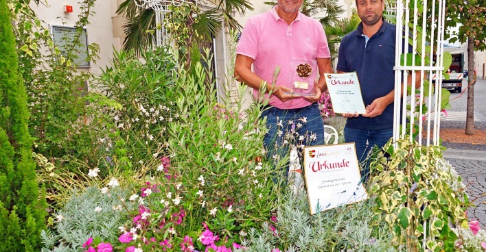 Gerhard Köfer und Daniel Santner mit den Urkunden inmitten von Pflanzen