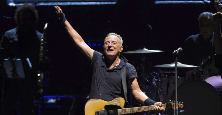Bruce Springsteen hebt die Hand und singt auf der Bühne