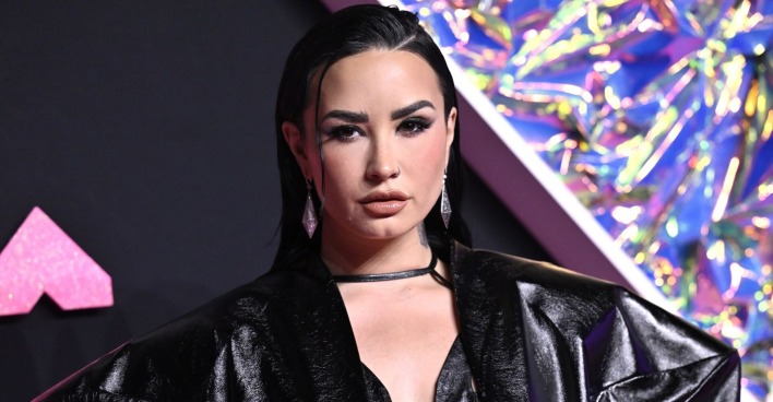 Demi Lovato mit Smokey Eyes und einem schwarzen Lackanzug am Red Carpet