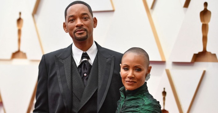 Will Smith trägt ein Sakko und Jada Smith ein hochgeschlossenes dunkelgrünes Kleid.