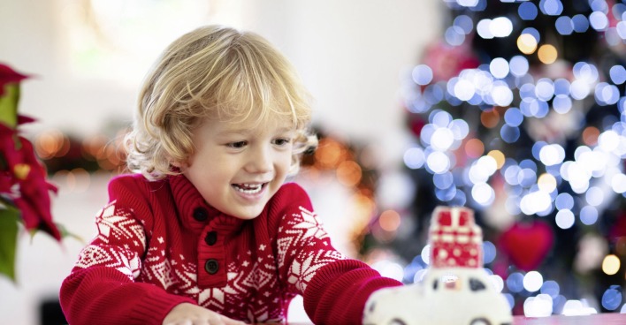 Kind freut sich über Spielauto zu Weihnachten.