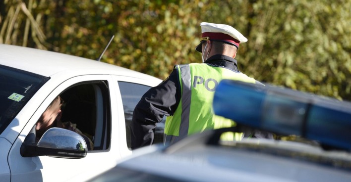 Ein Polizist kontrolliert einen Autofahrer.