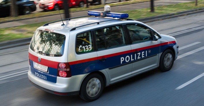 Ein Polizeiauto fährt auf einer Wiener Straße.