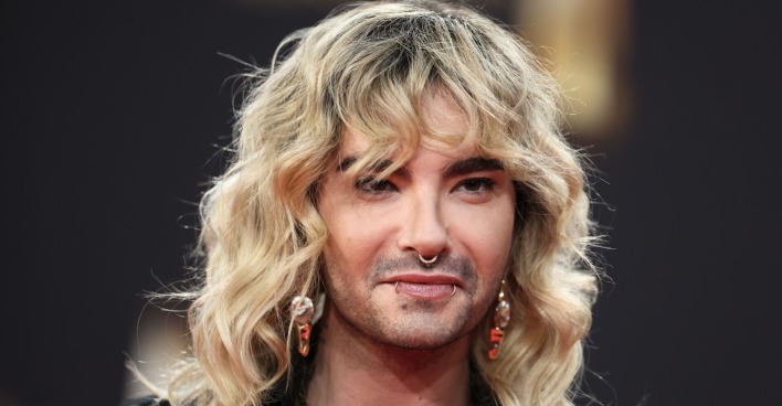 Bill Kaulitz mit blonden gewellten Haaren und Piercings im Gesicht.