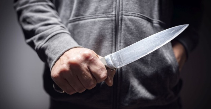 Ein Mann mit einem großen Messer in der Hand.