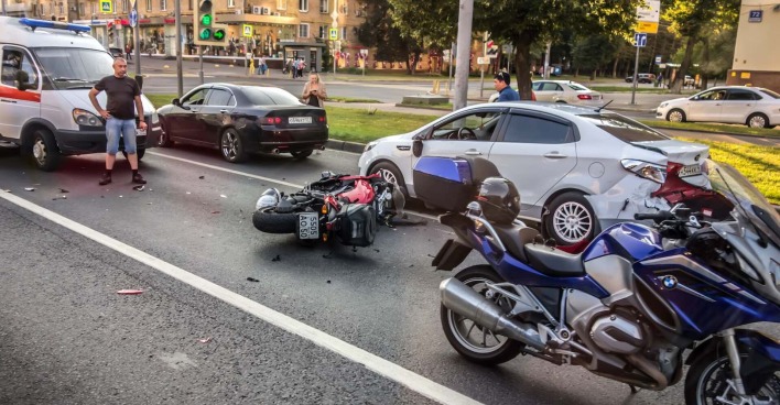 Ein Motorrad liegt vor eine Ampel auf der Straße.