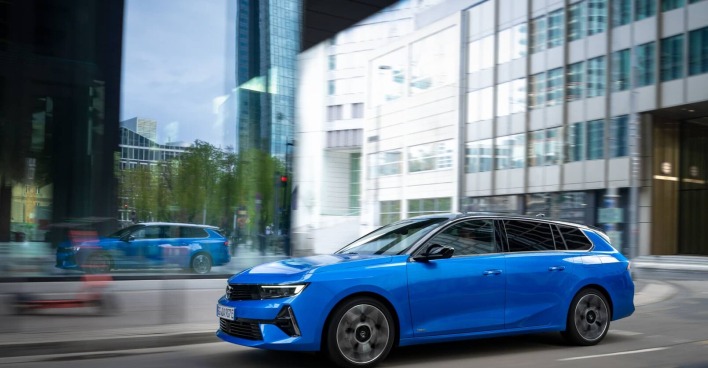 Ein blauer Opel Astra düst durch die Stadt. Den Opel Astra gibt es seit 1991.