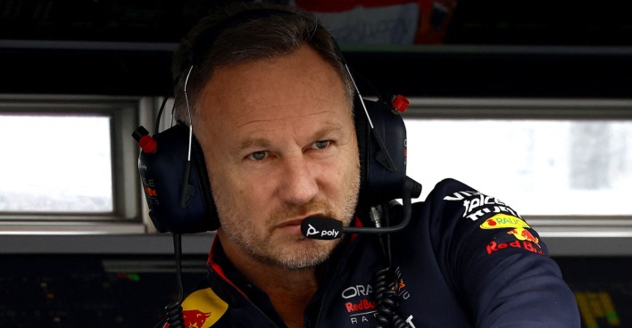 Christian Horner auf der Rennstrecke, er schaut sehr ernst und konzentriert. Er trägt ein Funkset