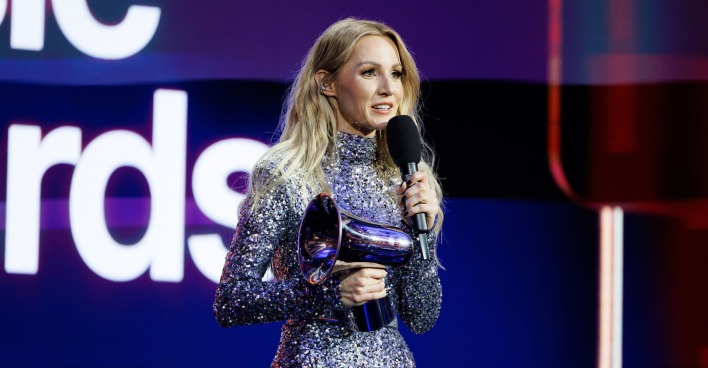 Melissa Naschenweng mit ihrem Austrian Amadeus Music Award und einem glitzer Outfit auf der Bühne.