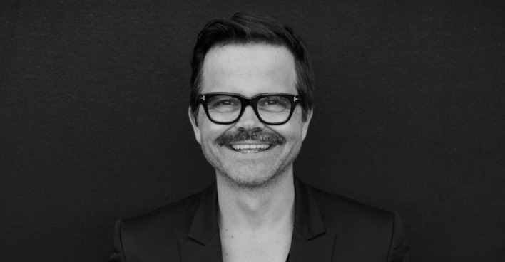 Ein schwarz-weißes Foto von einem Mann mit Brille