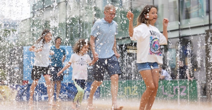 Menschen laufen durch Wasserspielplatz