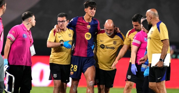 Der Spieler Marc Bernal verlässt, gestützt von zwei Betreuern das Feld
