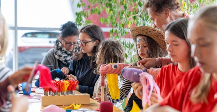 Gruppe von Kindern sitzt bastelnd am Tisch