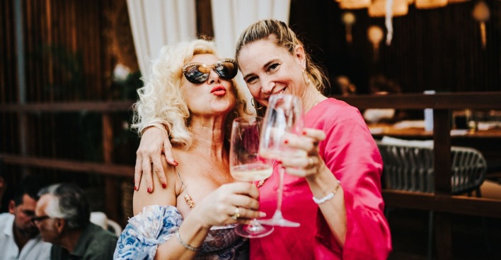 Zwei blonde Frauen stoßen miteinander an
