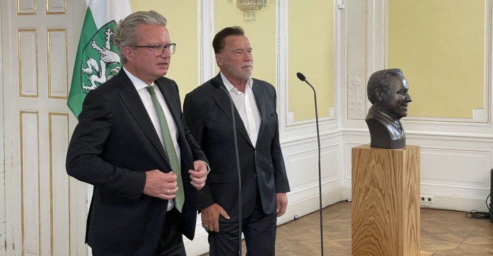 Zwei Männer in Anzügen stehen nebeneinander