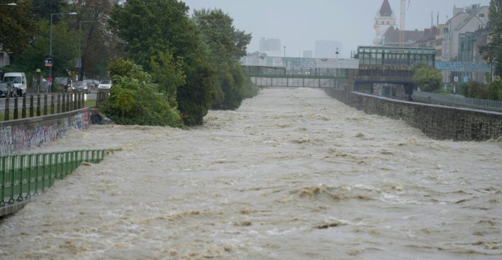 Der Wienfluss führt Hochwasser, Gehwege sind überschwemmt.