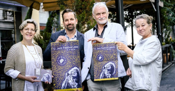 Zwei Männer und zwei Frauen halten Plakate hoch