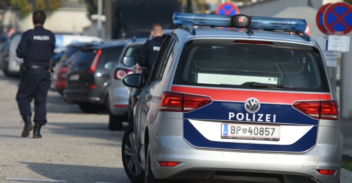 Polizist neben Einsatzfahrzeug