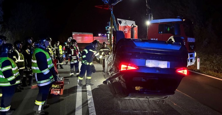 Einsatzkräfte der Feuerwehr vor Ort beim Unfallwagen.