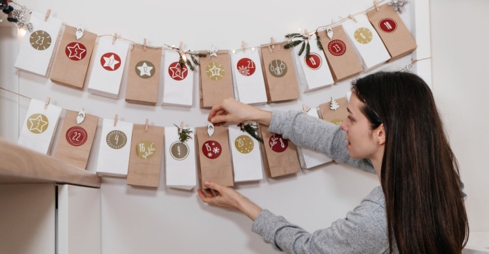 Frau hängt einen selbstgemachten Adventkalender an die Wand