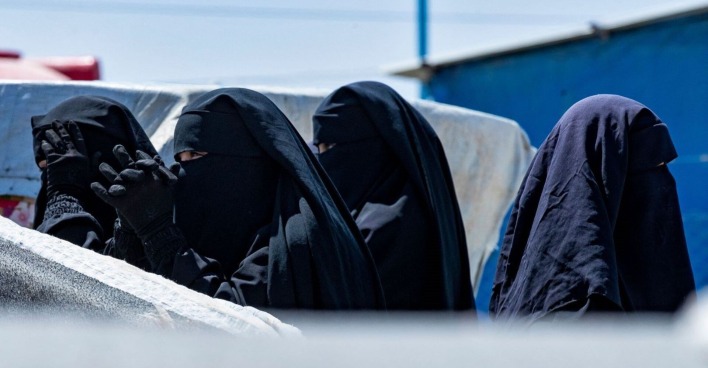 Vier vermummte Frauen in einem syrischen Camp.
