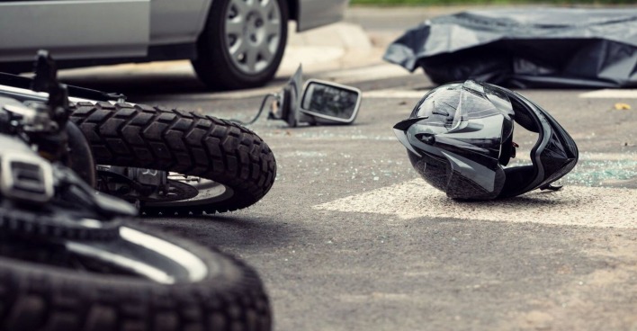 Helm und Motorrad liegen nach einem Unfall auf der Straße.