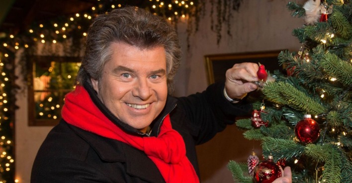 Andy Borg schmückt einen Weihnachtsbaum
