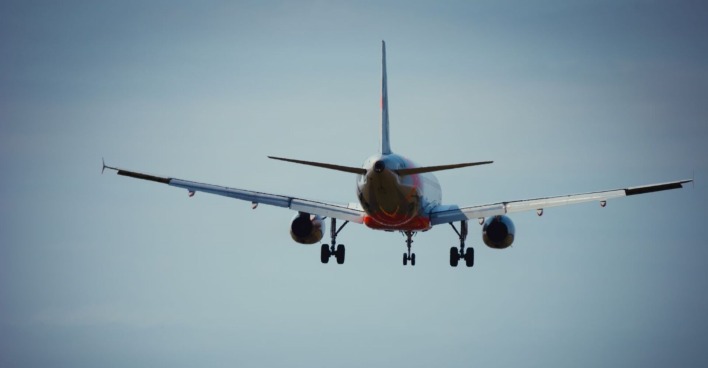 Ein Passagierflugzeug im Landeanflug, aufgenommen von hinten gegen den Himmel – symbolisch für kommende Änderungen bei Flughafenkontrollen.