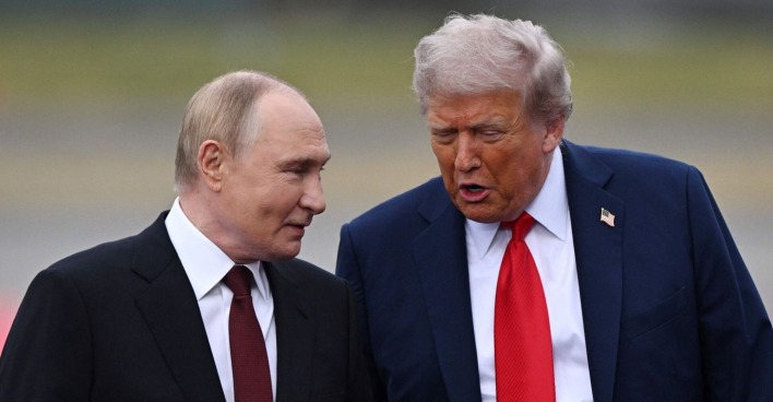 Donald Trump und Wladimir Putin gehen nebeneinander und sprechen miteinander beim Treffen in Alaska. Beide wirken freundlich und im Gespräch vertieft.