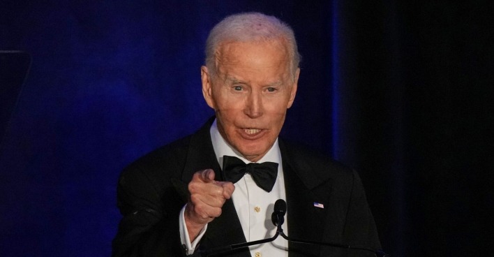 Joe Biden im schwarzen Smoking mit Fliege spricht bei einer Veranstaltung am Rednerpult und zeigt mit dem Finger nach vorne.