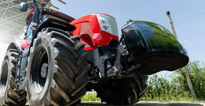 Roter Traktor steht an der Seite eines Feldes