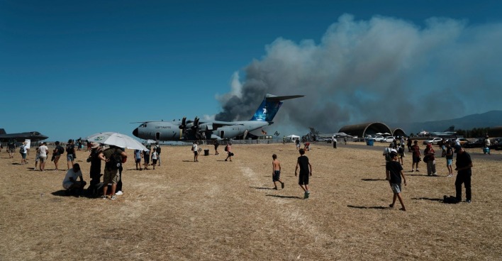 Dichte schwarze Rauchwolke steigt hinter Militärflugzeugen auf dem Flugplatz Tanagra auf