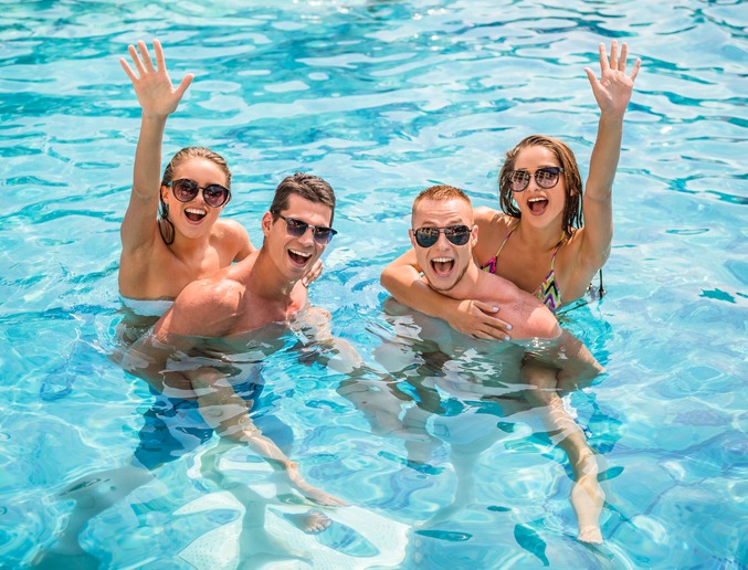 Zwei Pärchen plantschen im Schwimmbad