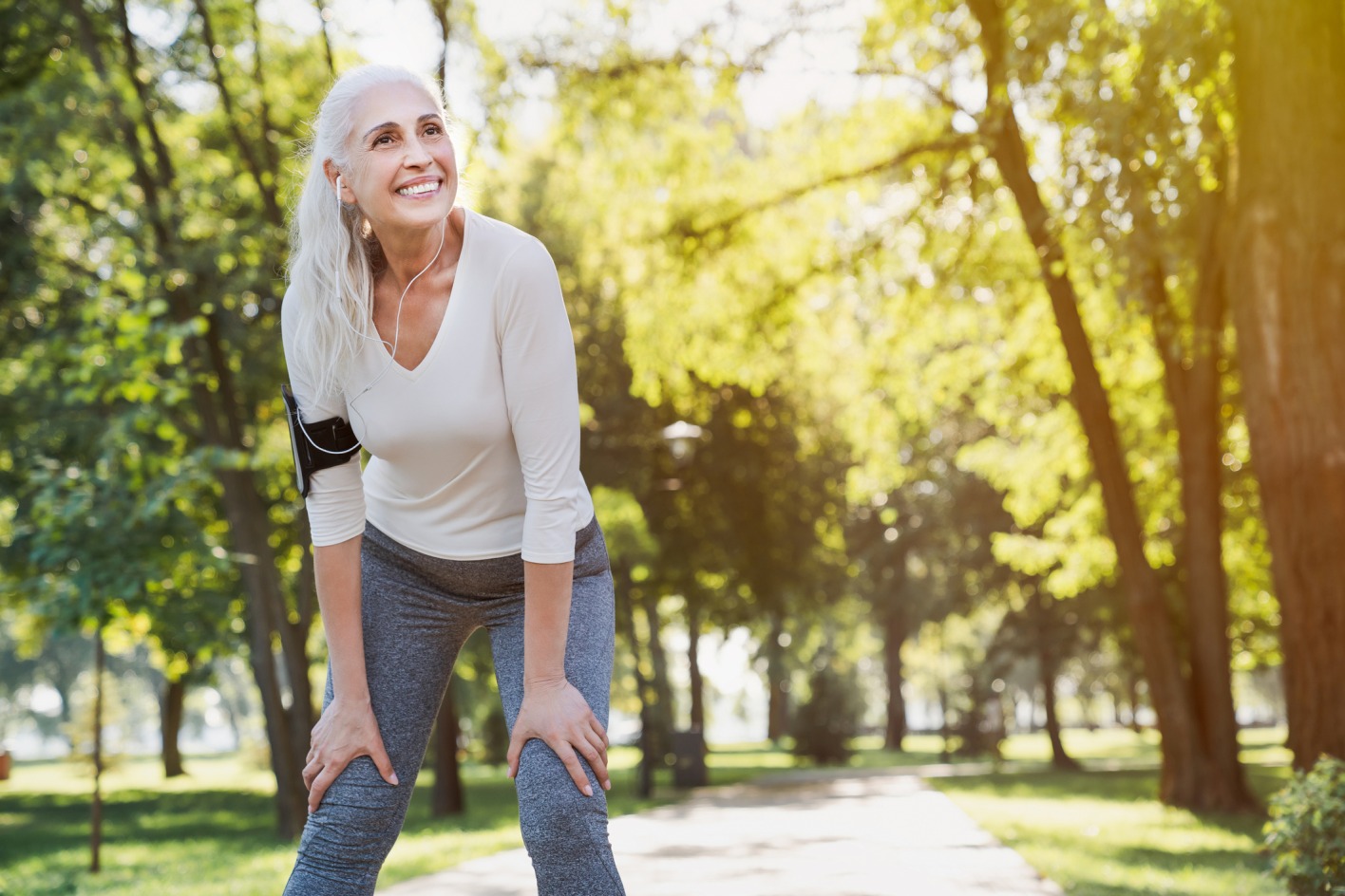 Eine sportliche ältere Dame legt eine Pause während des Lauftrainings ein