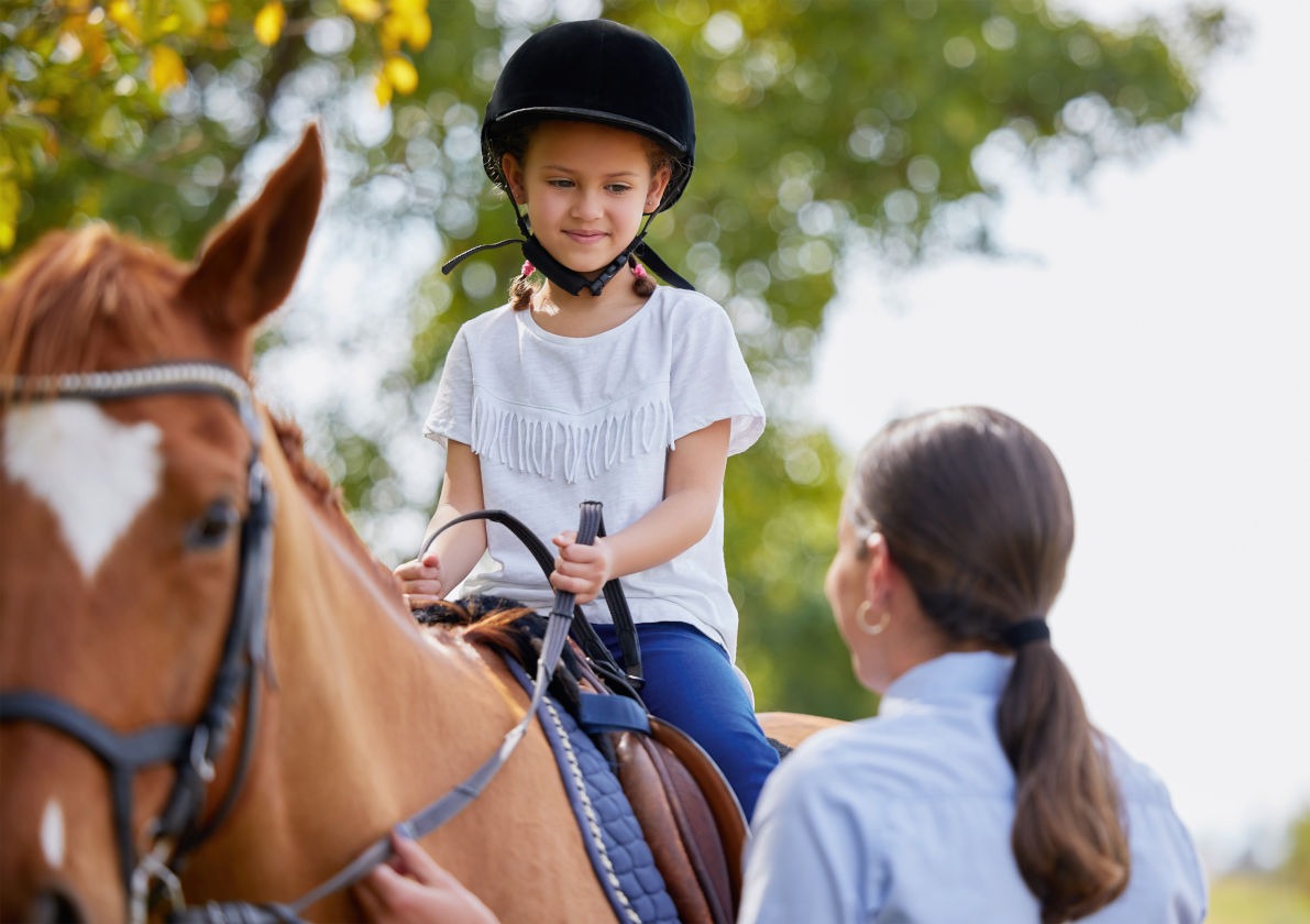 Mädchen auf Pferd beim Reiten